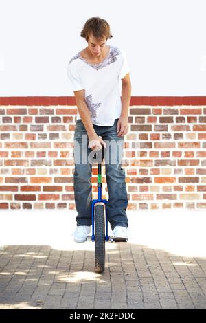Hes got skill. Full-length shot of a young man balancing on a unicycle. Stock Photo