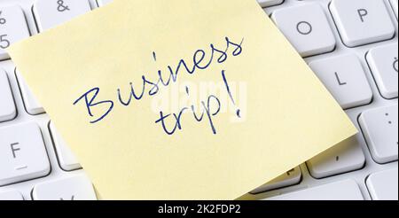 Sticky note on a keyboard - Business trip Stock Photo