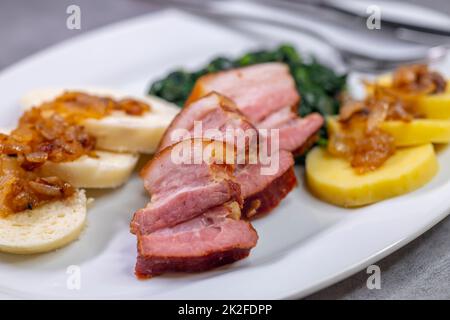 smoked flank with potato and bread dumplings and spinach Stock Photo