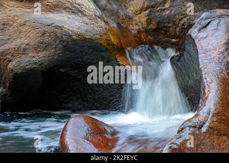 Small creek with waters running through the rocks Stock Photo