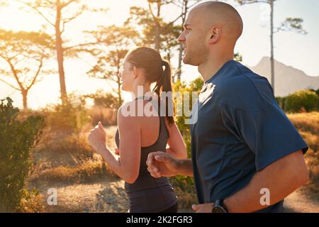 Running along their favorite nature trail. a young couple doing a trail run together. Stock Photo