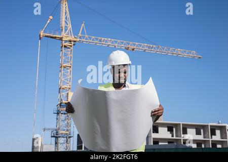 African American architect compares building to drawings Stock Photo