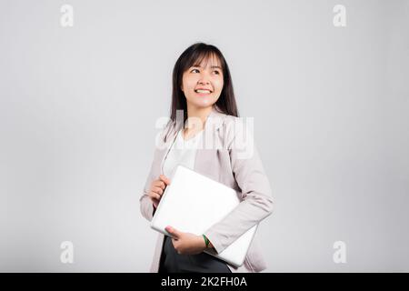 Side view woman smiling confident smiling holding closed laptop Stock Photo