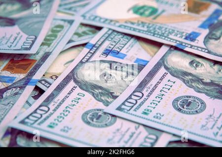 Cash hundred-dollar bills, banknotes are scattered dollar background image. Stock Photo