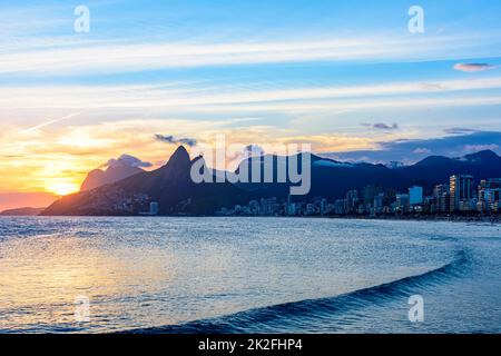 Sunset behind the mountains and sea Stock Photo
