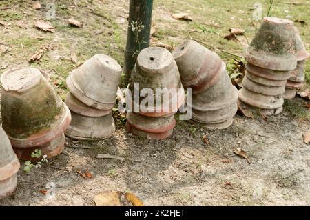 Stack of Earthen flower tubs on garden. Clay flower pots on the garden front yard. Stock Photo