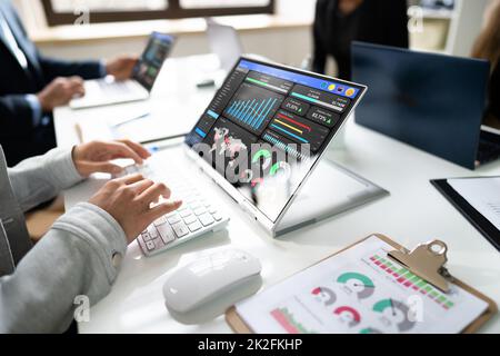Side View Of Businesspeople Examining Graph On Computer Stock Photo