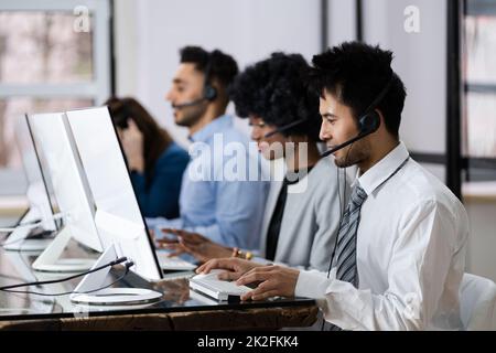 Positive Customer Services Agent With Headset Working Stock Photo