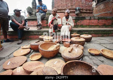 Nepal. 23rd Sep, 2022. People from Raute community waits for the customer to sell their wooden crafts in the ''˜Raute Exhibition' program held at Bhaktapur on Friday. The last nomadic ethnic group of Nepal, Raute are known for living in forest and hunting monkeys. They are one of the endangered community of South Asia. They live in temporary tents in remote parts of the forest. While they have a talent for crafting wood and creating striking household utensils, they use it to barter for food-grains with the local people. At present, government provides them certain amount as social secu Stock Photo