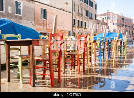 Colorful chairs in a row along Venetian canal Stock Photo