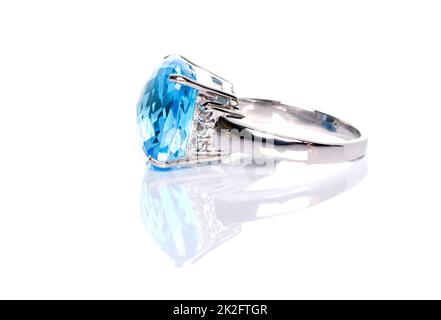 Cushion cut blue topaz ring on white background with reflection. Collection of natural gemstones accessories. Side View, Studio shot Stock Photo