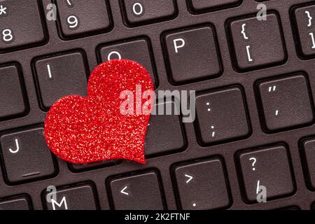 A red heart on a laptop keyboard Stock Photo