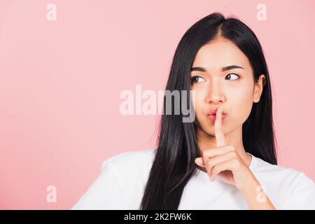 woman smile stand making finger on lips mouth silent quiet gesture Stock Photo