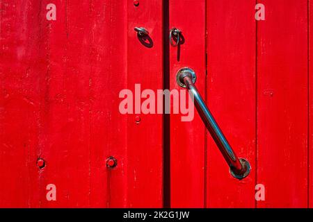 Old painted wooden red door with door handle Stock Photo
