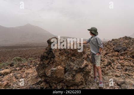 A teenager stands on an observation deck high in the mountains. In the background is the Teide volcano. Tenerife. Canary Islands. Spain. Stock Photo