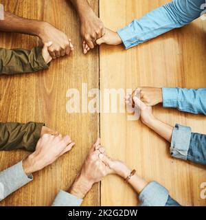 Seeking a little divine intervention. High angle shot of a group of unrecognizable university students praying for help with their upcoming exams. Stock Photo