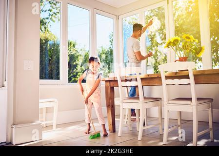 Helping Dad with some spring cleaning around the house. Shot of a father and his little daughter doing chores together at home. Stock Photo