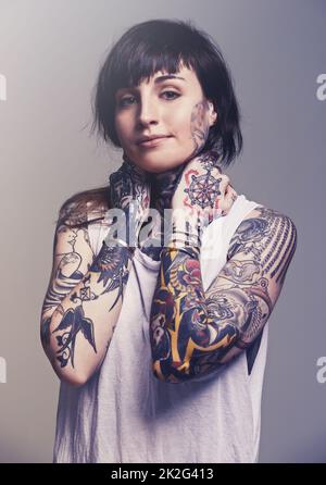 Inked. A cropped studio portrait of a tattooed young woman. Stock Photo