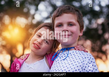 Nothing beats having a big brother. Shot of a little boy and his sister standing outside. Stock Photo