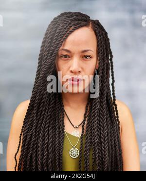 Long an beautiful braids. Portrait of an attractive young woman with beautiful braids posing outdoors. Stock Photo