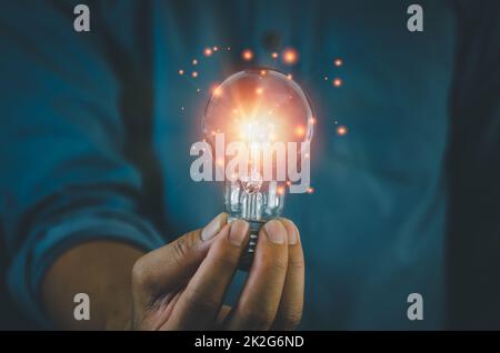 hand hold light bulb on black background.Inspiration and Creativity Concepts. Stock Photo