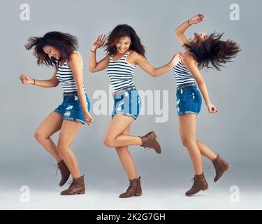 Shes a free-spirit. Composite image of a carefree young woman posing in studio. Stock Photo