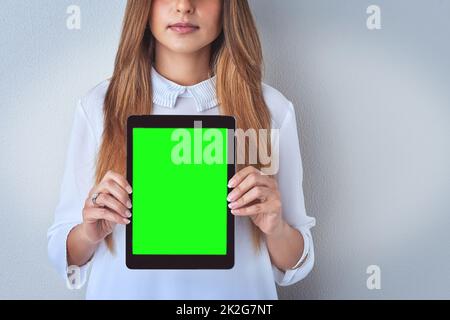 Shes standing behind her comments. Shot of an unrecognizable woman holding a digital tablet against a blue background. Stock Photo