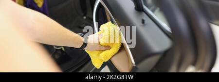 Car cleaner that cleans car door panel with microfiber cloth Stock Photo