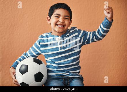 When Im big, Im gonna be a soccer star. Portrait of an adorable little boy posing with a soccer ball. Stock Photo