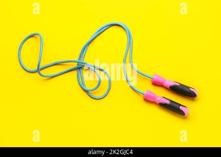 Skipping rope on yellow background Stock Photo - Alamy