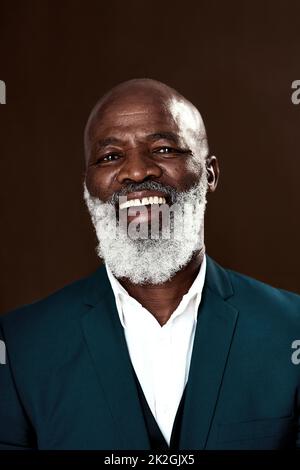 Staying positive is whatll help you win. Studio shot of a mature businessman posing against a brown background. Stock Photo