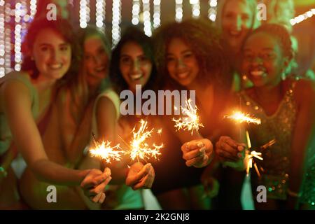 Good friends, good times. Shot of a group of girlfriends having fun with sparklers on a night out. Stock Photo