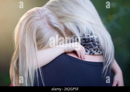 Finding comfort in her mothers arms. Cropped shot of a mother consoling her little girl. Stock Photo