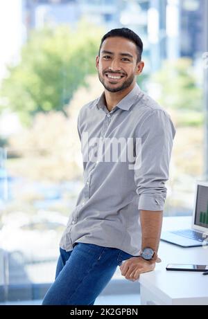 Let no one discourage your ambitions. Portrait of a confident young businessman standing in an office. Stock Photo