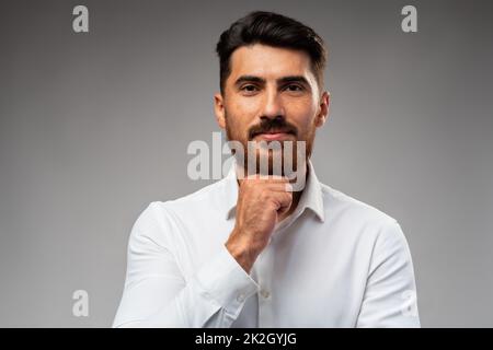 Studuo shot of thinking businessman standing over gray background Stock Photo