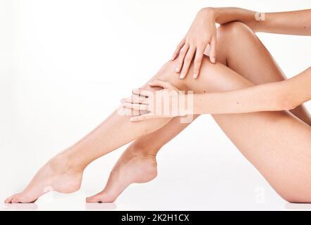 You cant help but touch it. Cropped shot of an unrecognizable womans legs in studio against a grey background. Stock Photo