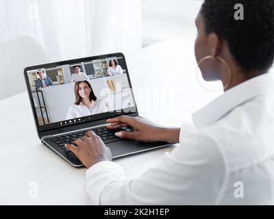 Web meeting. International video chat. Corporate telework. Business woman using laptop working on project with diverse colleagues on screen in virtual Stock Photo