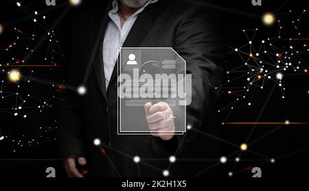 a businessman in a suit stands with a magnifying glass and examines the candidate's resume for the position. Search for talented employees, career growth Stock Photo