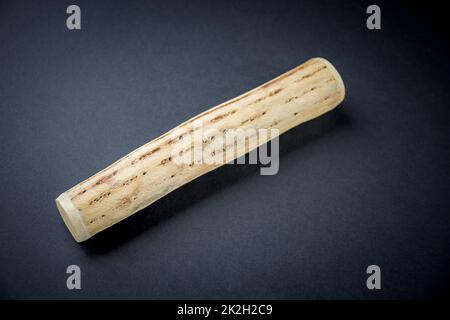 Traditional rain stick made of cactus wood isolated on black Stock Photo