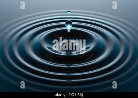 Water drop falling into water surface Stock Photo