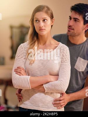 I cant even look at you right now. Shot of a young man trying to talk to his girlfriend after they had a fight at home. Stock Photo