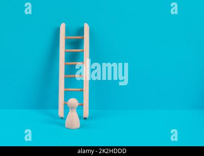 Man is standing next to a ladder, climbing up in career, having a goal, brainstorming for ideas, success strategy, taking a challenge, business concept Stock Photo