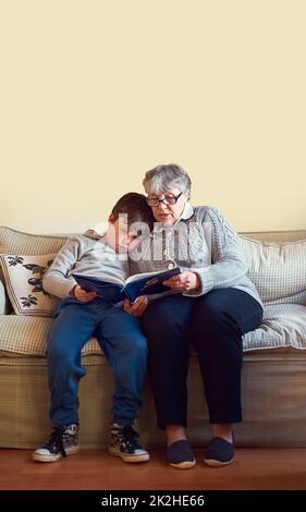 Its their favourite book to enjoy together. Shot of a grandmother reading a book to her grandson at home. Stock Photo