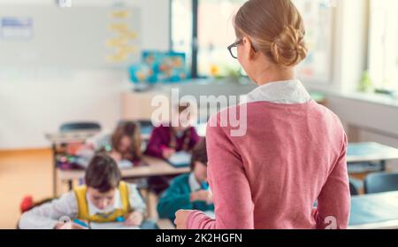 Teacher with her students in class at elementary school Stock Photo