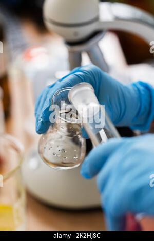 Scientist pouring substance from one flask to another in a laboratory Stock Photo