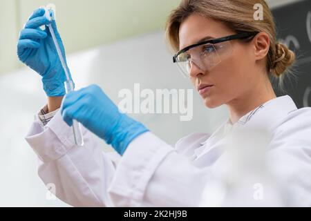 Scientist is using dropper and test tube in a laboratory during research Stock Photo