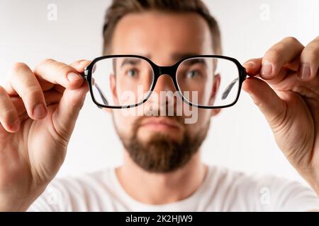 Young man holding eyeglasses in his hands Stock Photo