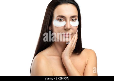 Middle aged woman with applied sheet patches under her eyes. Stock Photo