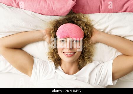Beautiful woman with curly hair waking up after good sleep Stock Photo
