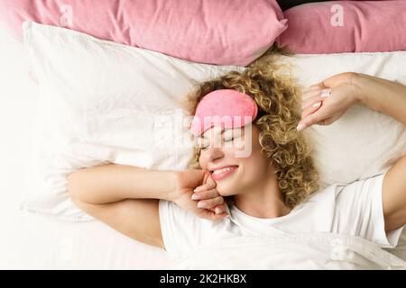 Beautiful woman with curly hair waking up after good sleep Stock Photo